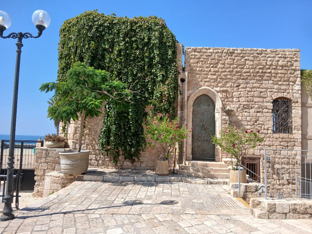 A stone house under ivy, with the sea on the left